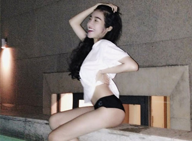 Elly Trần mặc áo pull trắng và quần bikini đi bơi