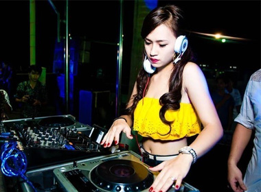 Nữ DJ Việt nổi bật với chiếc áo quây nhiều màu sắc, để lộ vai trần, eo thon gọn.