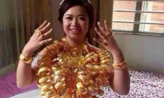 Cô dâu đeo vòng vàng nặng trĩu cổ, phải dùng hai tay đỡ mới chịu được Cô dâu đeo vòng vàng nặng trĩu cổ, phải dùng hai tay đỡ mới chịu được