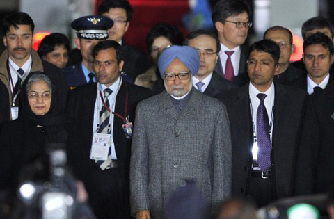 REPUBLIC OF KOREA, SEOUL : India's Prime Minister Manmohan Singh (C) walks with his wife Gursharan Kaur (L) down the red carpet upon his arrival at the air base in Seoul on March 24, 2012 ahead of the 2012 Seoul Nuclear Security Summit. Leaders from over 50 nations will attend the summit on March 26-27. AFP PHOTO / POOL / NICOLAS ASFOURI