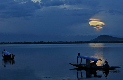 Một người đàn ông chèo thuyền trong một ngày mua gió trên hồ Dal ở Sringagar, Ấn Độ.