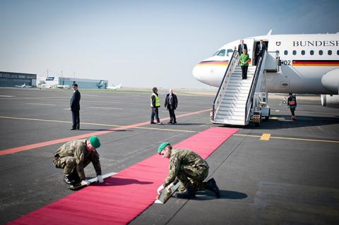 Thủ tướng Đức Angela Merkel chờ các binh sĩ trải thảm đỏ tại sân bay ở Prague, CH Czech.