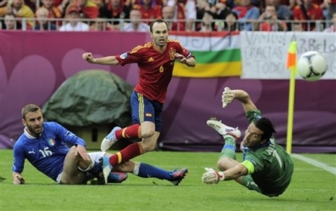 Spain's Andres Iniesta fails to score past Italy's Daniele De Rossi, left, and Italy goalkeeper Gianluigi Buffon, right, during the Euro 2012 soccer championship Group C match between  Spain and Italy in Gdansk, Poland, Sunday, June 10, 2012.