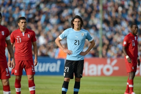 Uruguayan forward Edinson Cavani (C) awaits for a shoot alongside Peruvian player Jesus Martin Alvarez during their Brazil 2014 FIFA World Cup South American qualifier match at the Centenario stadium in Montevideo on June 10, 2012.