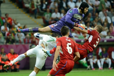 Czech goalkeeper Petr Cech (top) jumps to deflect the ball during the Euro 2012 football championships quarter-final match the Czech Republic vs Portugal on June 21, 2012 at the National Stadium in Warsaw.