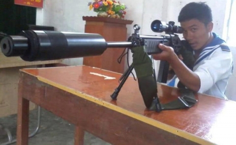 Một chiến sĩ trong lực lượng hải quân đánh bộ của Việt Nam chụp hình với súng bắn tỉa Tavor TAR-21 có giảm thanh do Israel chế tạo