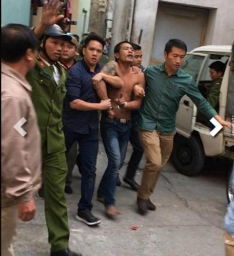   Huân bị lực lượng công an khống chế sau nhiều giờ cố thủ trong nhà (Ảnh Beatvn).  