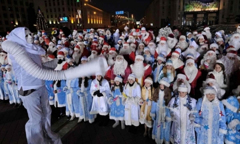   Một người đàn ông ăn mặc như Ông già mùa đông (Father Frost) và các Thiếu nữ Tuyết trong một cuộc diễu hành Giáng sinh truyền thống tại Belarus. (Ảnh: Maxim Malinovsky / AFP / Getty Images)  