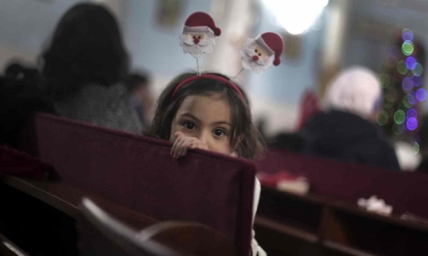   Một bé gái người Palestine đang chuẩn bị làm lễ đêm Giáng sinh tại nhà thờ Holy Family Catholic, Palestine. (Ảnh: Khalil Hamra / AP)  