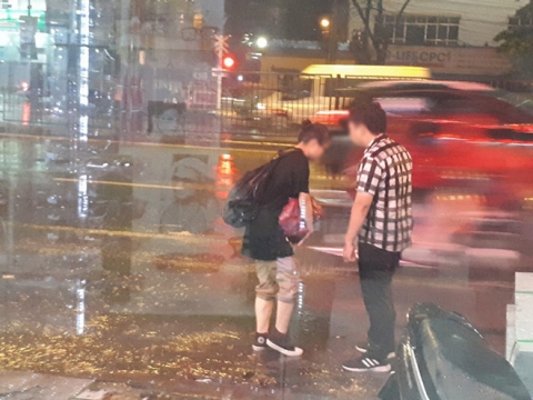 Bất chấp mưa bão, chàng trai nằm lăn ra đường 