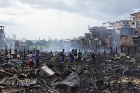 Cư dân đứng trong khu phố sau đám cháy thiêu rụi khoảng 600 ngôi nhà gỗ. Ảnh: AP. 