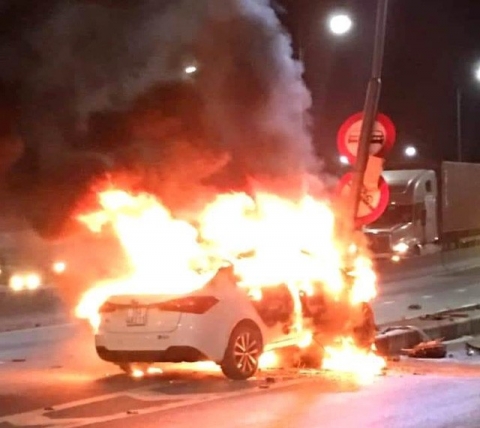 Sau khi đâm phải cột đèn tìn hiệu giao thông, chiếc xe ô tô bất ngờ bốc cháy. Ảnh: Bạn đọc cung cấp