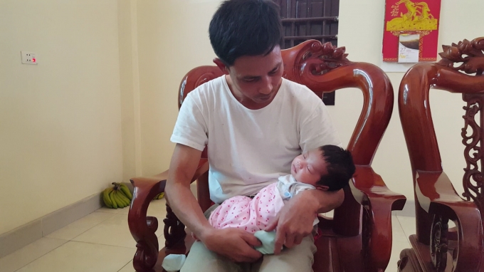 Anh Đàm Văn Hưởng (chồng sản phụ Nguyễn Thị Kha) phải ở nhà chăm con sau khi vợ mất. Ảnh: Huy Trung