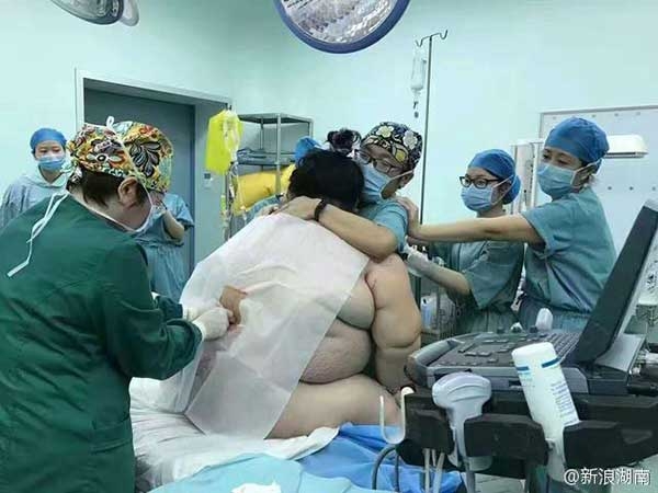   Các bác sĩ, nhân viên y tế đỡ ở phía sau và liên tục hỏi sản phụ có chỗ nào khó chịu không. (Ảnh: Sina Weibo)  