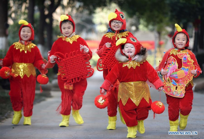 Các em nhỏ ở thành phố Hợp Phì, tỉnh An Huy, Trung Quốc hóa thân thành những chú gà trống đi tặng quà cho những người cao tuổi. (Ảnh: Xinhua)