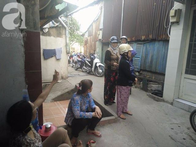 Một người dân chỉ đường cho những người thân của vợ chồng bà L. đến nhà tang lễ để viếng thăm.