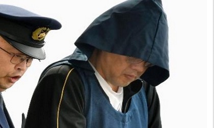 Nghi phạm sát hại bé Nhật Linh xuất hiện trong chiếc khăn trùm đầu, mặt cúi gằm, tránh ống kính của phóng viên