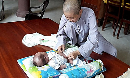 Bé trai quấn trong khăn bị bỏ rơi trước cổng chùa