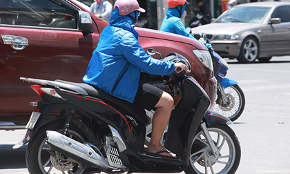 Đàn ông mặc áo rét để chống lại nắng nóng như đổ lửa ở HN