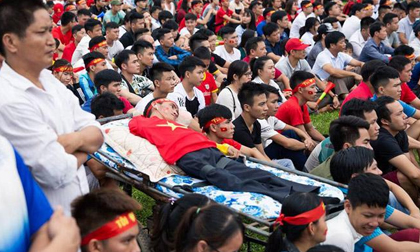 Xúc động hình ảnh người đàn ông khuyết tật chân tay nằm trên xe cáng cổ vũ U23 Việt Nam