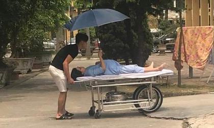 Bức ảnh chồng đẩy xe, vợ bầu nằm cáng vẫn che ô cho chồng khiến cộng đồng mạng dậy sóng