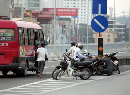 Cánh xe ôm đứng tràn lan trên đường, hễ thấy xe khách có ý định dừng là chạy theo đón khách (Ảnh: Infonet)