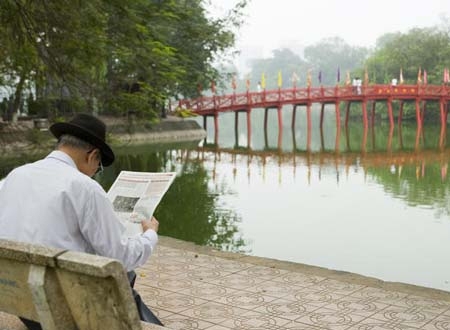 Ông già ngồi đọc báo bên Hồ Gươm thanh bình