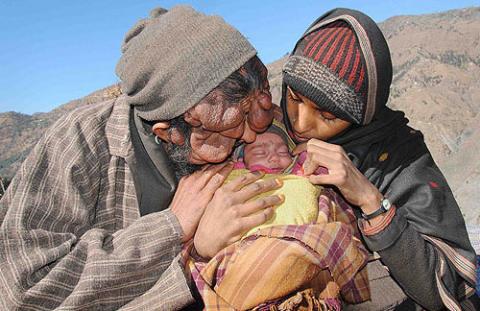 Người đàn ông mang gương mặt quỷ dữ âu yếm đứa con gái mới sinh.