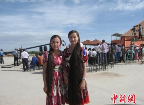  Ngô Nhĩ Khắc Tư (đứng bên phải) cạnh một cô gái tham gia cuộc thi 