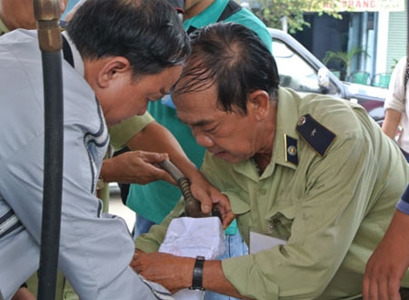 Đoàn kiểm tra niêm phong cần bơm xăng của cây xăng Lan Anh. Ảnh: THANH NHÂN