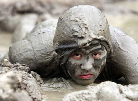 Một người lính đặc công được ngụy trang bằng bùn đất đang lặng lẽ áp sát mục tiêu