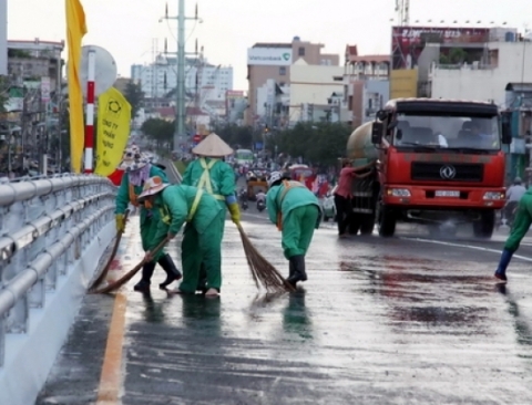 Công nhân đang chùi, rửa mặt đường trước giờ thông xe