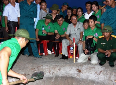 Nguyễn ThanhThúy (ngồi giữa) chỉ đạo cất bốc hài cốt liệt sỹ tại thôn Lâm Xuân, xã Gio Mai (huyện Gio Linh, Quảng Trị) vào ngày 25/7. Ảnh: Quang Hà