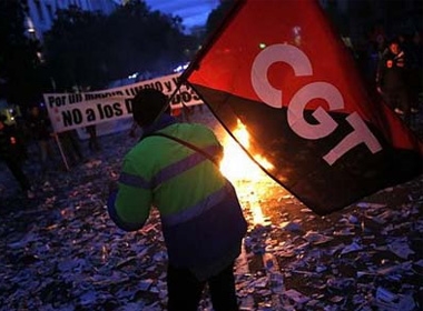 Một người biểu tình giơ lá cờ của liên đoàn lao động trong cuộc bãi công