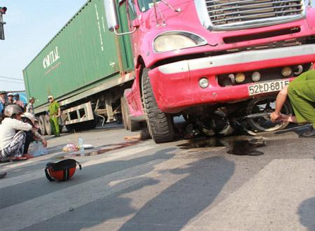 Chiếc xe máy lọt thỏm dưới gầm xe container