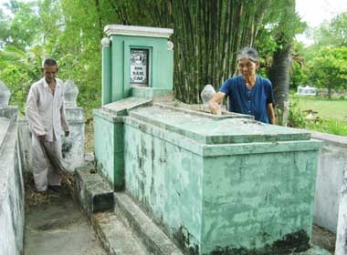 Vợ chồng bà Diêm bên ngôi mộ ông Cao Nhà Bàng.