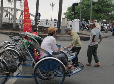 Các chú xích lô đang đứng đón khách ở ngã tư.