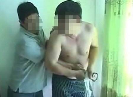 Một người đàn ông cầm còng số 8 khống chế ông Vương (Ảnh cắt từ clip)