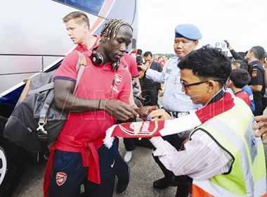 Hậu vệ Bacary Sagna ký tặng nhân viên sân bay ngay sau khi hạ cánh xuống Jakarta, Indonesia. ảnh: Arsenal.com.