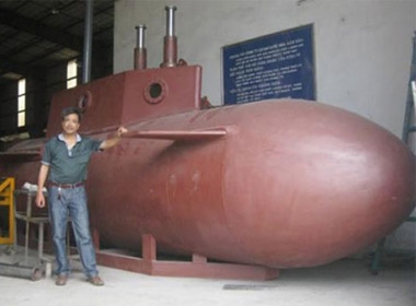 Ông Hòa bên chiếc tàu ngầm tự chế. Ảnh: Nhân dân