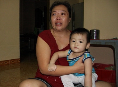 Chị Cao Kim Huệ và con trai 11 tháng tuổi trông tin chồng