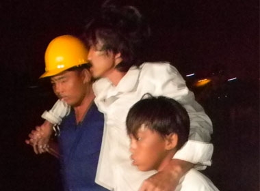 Anh Nguyễn Văn Hồng được lực lượng tìm kiếm cứu nạn dìu xuống tàu
