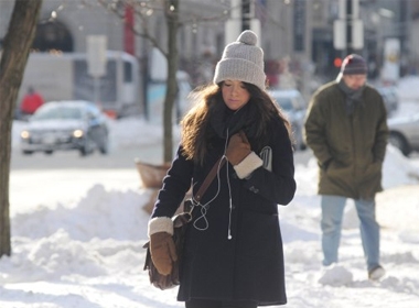 Một người phụ nữ Mỹ đi trên con đường phủ trắng tuyết tại thành phố Boston, bang Massachusetts