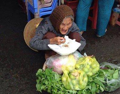 Một cụ già bé nhỏ, gầy gò ngồi giữa đường bán rau 