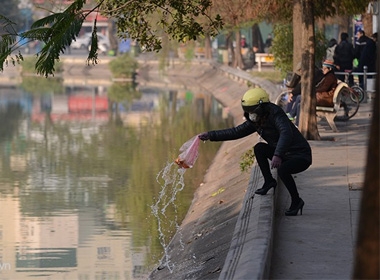 Sáng sớm, nhiều phụ nữ tranh thủ thả cá trên đường đi làm tại hồ Gươm