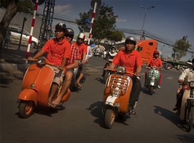 Du khách khám phá Sài Gòn trên xe Vespa. Ảnh: vietnamvespaadventures