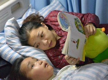 Cô Zhou đọc truyện cho con trai nghe, cậu bé gần như đã bị mất thị lực vì căn bệnh ung thư não
