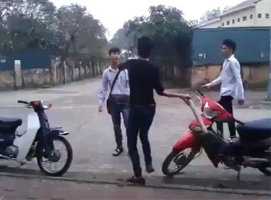 Nam thanh niên dùng điếu cày vụt liên tiếp các nam sinh khác ngay bên ngoài cổng trường - Ảnh chụp màn hình clip