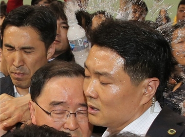 Vệ sĩ che chắn cho Thủ tướng Hàn Quốc khỏi sự phẫn nộ của người dân