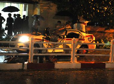 Chiếc taxi bẹp dúm do bị cây cổ thụ đổ vào. 